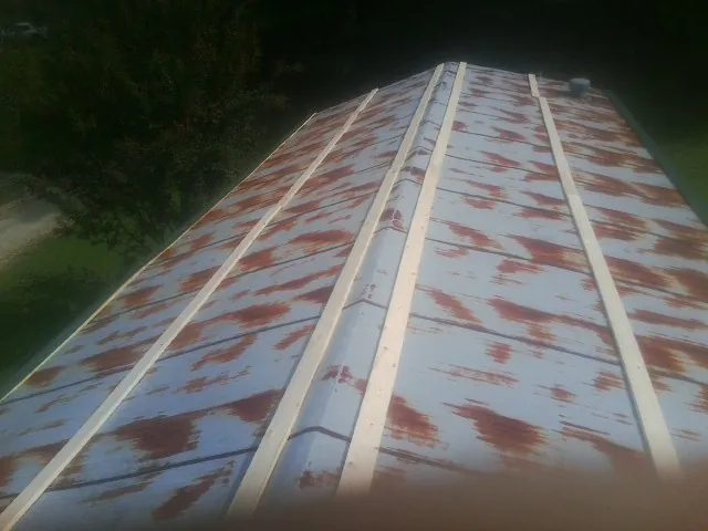 Rusted metal roof panels with new wood purlins before replacement — Storm Damage Roof Repair in Largo by Roofing Brothers