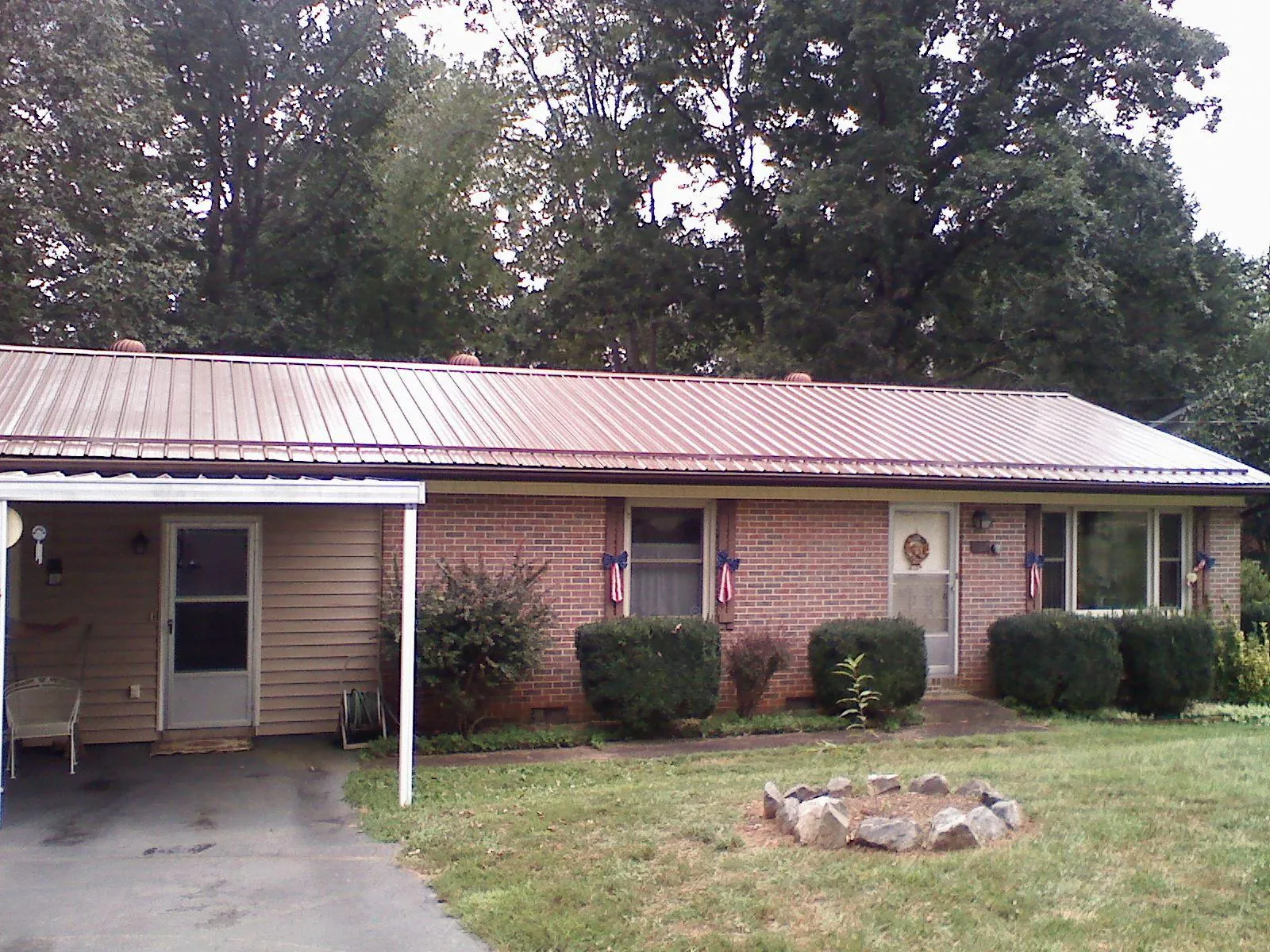 Bronze metal roof and carport on a brick ranch home — Roof Repair work by our crew in Largo