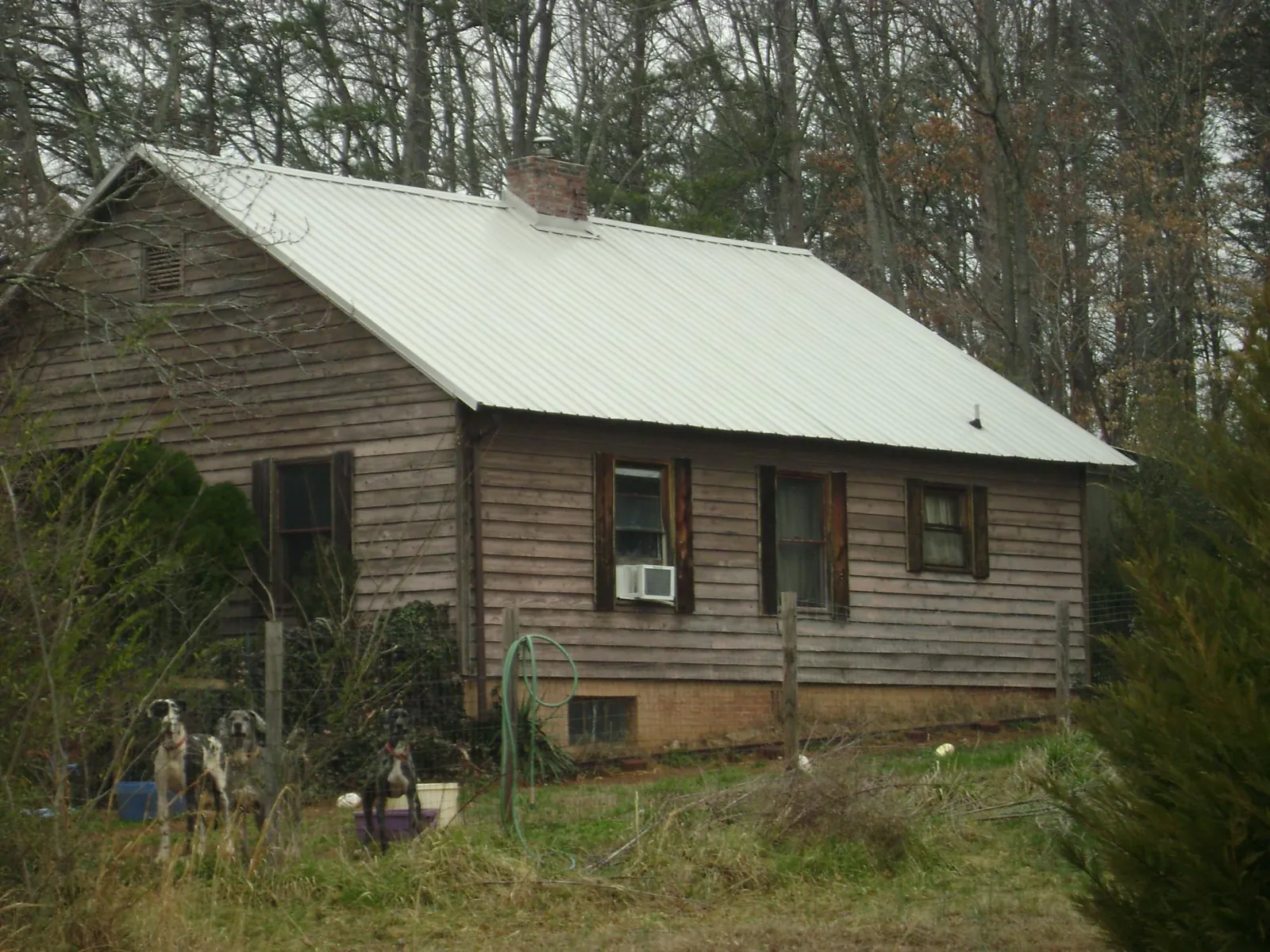 White metal roof on an old wood sided farmhouse, from a Metal Roof Installation job in Largo